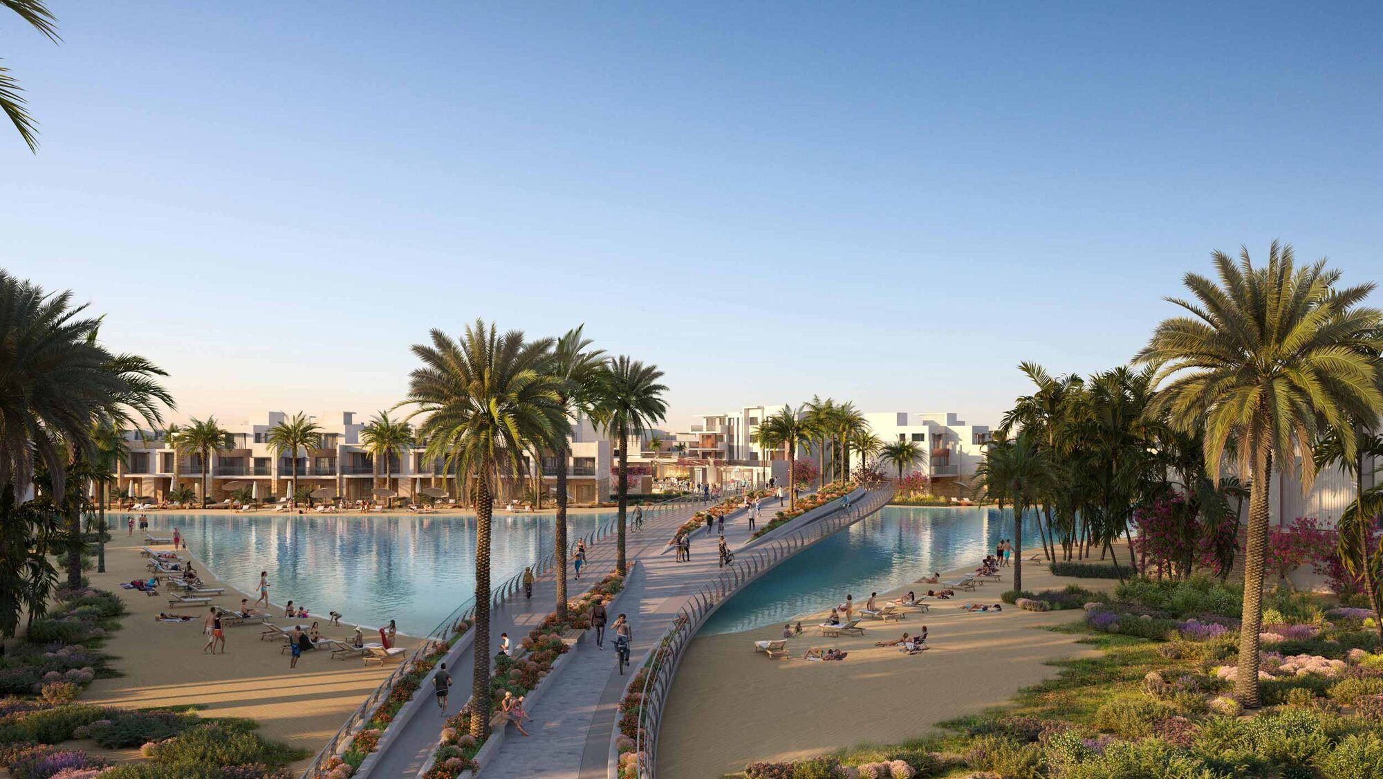 A swimmable crystal lagoon lined with palms and low white residences at Silversands